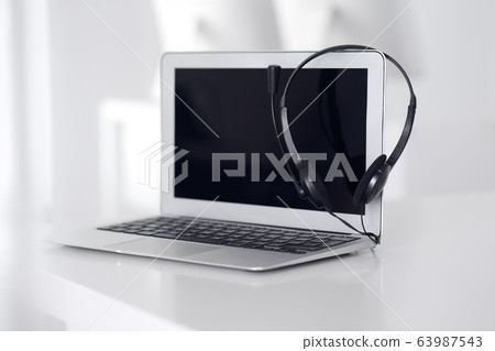 Call center and communication support, customer service help desk. VOIP headset on laptop computer Call center and communication support, customer service help desk. VOIP headset on laptop computer 63987543