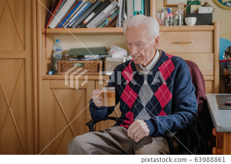 Old man drinking coffee at home 63988861