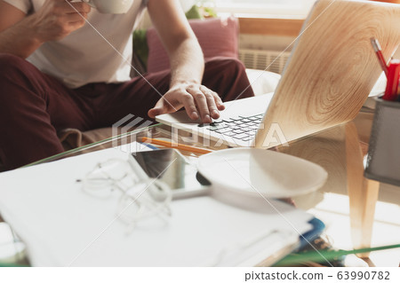 Young man studying at home during online courses for financist, economist, managers Young man studying at home during online courses for financist, economist, managers 63990782