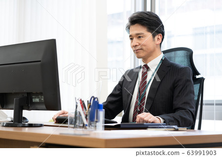 Manager talking to subordinates in office 63991903