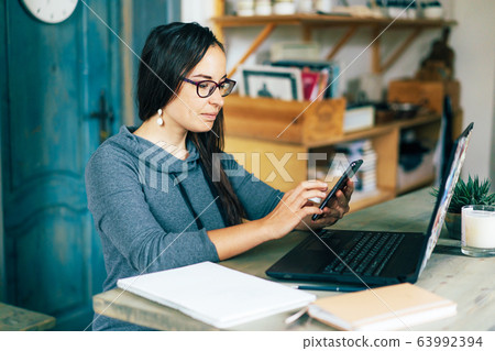 .woman at home with laptop and smartphone 63992394