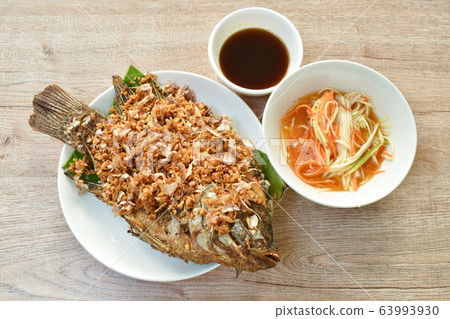 batter fried mango fish topping chop garlic dipping sweet and soy sauce  63993930