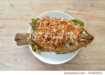 batter fried mango fish topping chop garlic dipping sweet and soy sauce  63993931