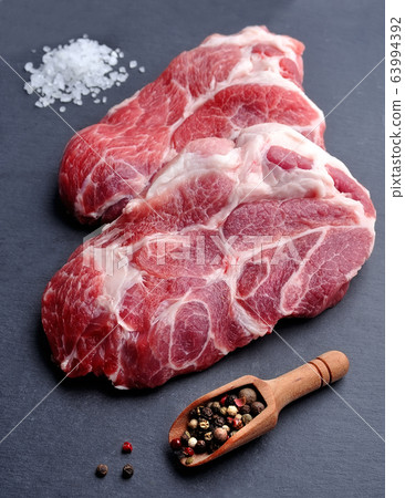 Crude meat on black board. Crude meat on black board. 63994392