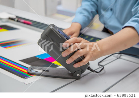 Improve hand to measure density of printed matter in offset printing. Image of color management and quality control Improve hand to measure density of printed matter in offset printing. Image of color management and quality control 63995521