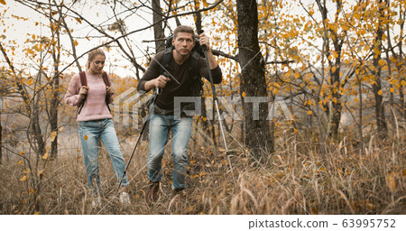 Loving couple makes their way through thicket Loving couple makes their way through thicket 63995752