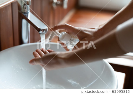 Close up young woman cleaning hands with soap. Close up young woman cleaning hands with soap. 63995815