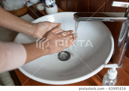 Close up young woman washing hands with antiseptic bubble soap. Close up young woman washing hands with antiseptic bubble soap. 63995816