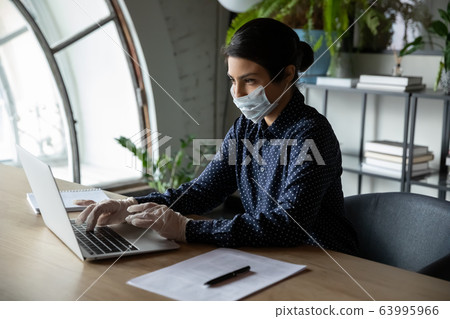 Indian company employee working on laptop at workplace. Indian company employee working on laptop at workplace. 63995966