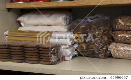 Provision shelf with buckwheat, sugar, biscuits, vermicelli and dried fruits Provision shelf with buckwheat, sugar, biscuits, vermicelli and dried fruits 63996667