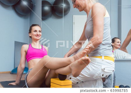 Woman with physical therapist doing fascial training with roll 63998785