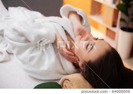 Pretty woman receiving a relaxing massage at the spa salon 64000009