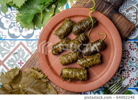 Latin American Mexican Chilean cuisine. Ninos envueltos. Grape leaves stuffed wish meat on clay 64002246