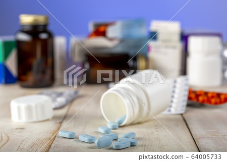 Home therapy. Open bottle with blue pills. Home therapy. Open bottle with blue pills. 64005733