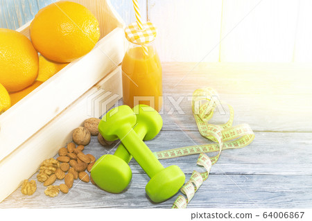 Lots of oranges, dumbbells, measuring tape on a Lots of oranges, dumbbells, measuring tape on a 64006867