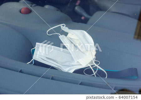 Closeup of medical masks on the dashboard of car Closeup of medical masks on the dashboard of car 64007154