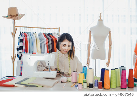 Designer using sewing machine in working. Designer using sewing machine in working. 64007546