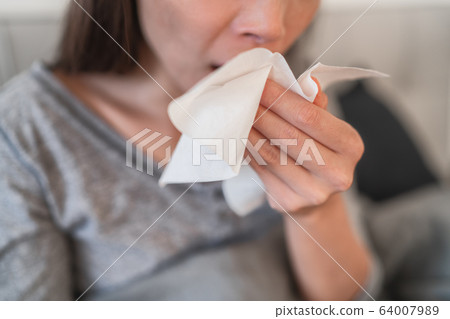 Cough in tissue covering nose and mouth when coughing as COVID-19 hygiene guidelines for coronavirus spread prevention 64007989
