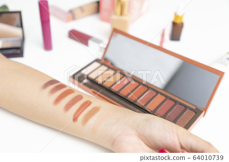 Closeup of hand makeup artist testing different 64010739