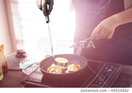 cooking from home , she is cooking cake at home cooking from home , she is cooking cake at home 64010882