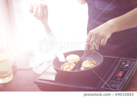 cooking from home , she is cooking cake at home cooking from home , she is cooking cake at home 64010883