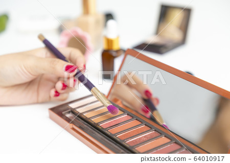 Closeup of hand makeup artist testing different Closeup of hand makeup artist testing different 64010917