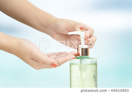 Hands female using wash hand sanitizer gel pump 64010983
