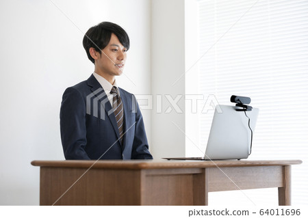 A young man heading for a laptop with a webcam Job hunting image A young man heading for a laptop with a webcam Job hunting image 64011696