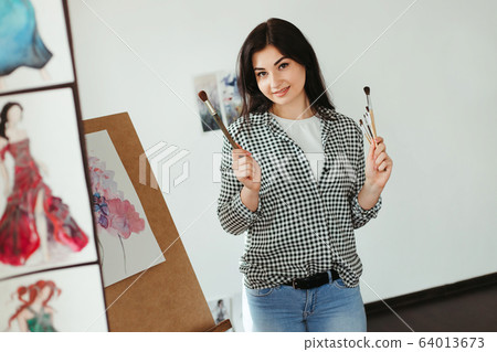 Woman painting with watercolor at home studio 64013673