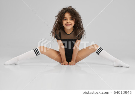 Young female gymnast sitting on floor. Young female gymnast sitting on floor. 64013945