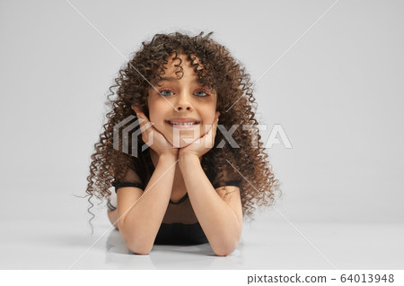 Little female gymnast posing on studio floor. Little female gymnast posing on studio floor. 64013948