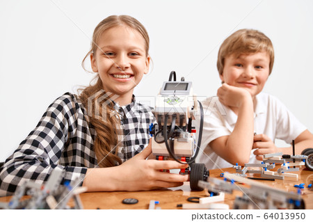 Young friends using building kit. Young friends using building kit. 64013950