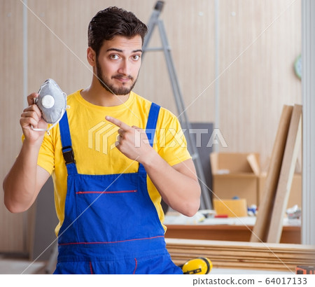 Young repairman carpenter working cutting wood 64017133