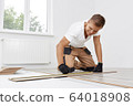 Man installing new wooden laminate flooring 64018908