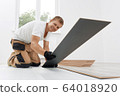 Male worker installing laminate flooring 64018920