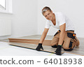 Man installing new wooden laminate flooring 64018938
