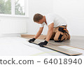 Male worker installing laminate flooring 64018940