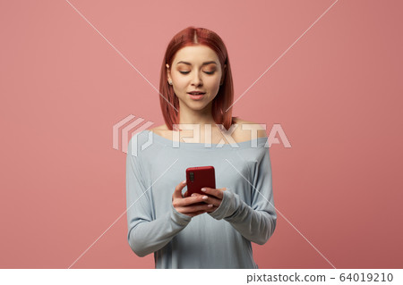 Serious young woman with phone in her hands 64019210