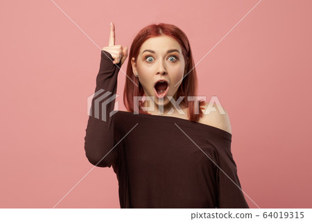 Surprised ginger woman with gray eyes with raised hand 64019315