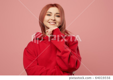 Smiling girl in red sweatshirt isolated empty pink background in studio Smiling girl in red sweatshirt isolated empty pink background in studio 64019338
