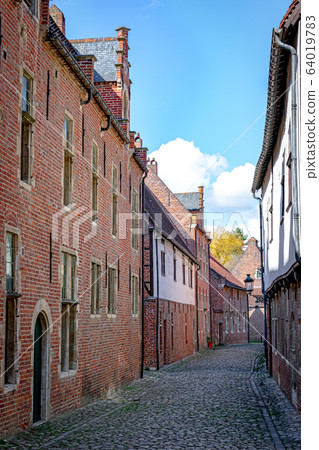 Empty cobblestone streets with red brick buildings Empty cobblestone streets with red brick buildings 64019783