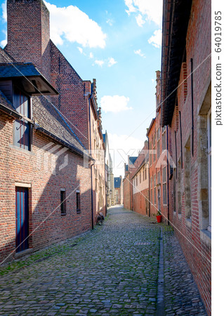 Empty cobblestone streets with red brick buildings Empty cobblestone streets with red brick buildings 64019785