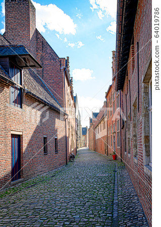 Empty cobblestone streets with red brick buildings 64019786
