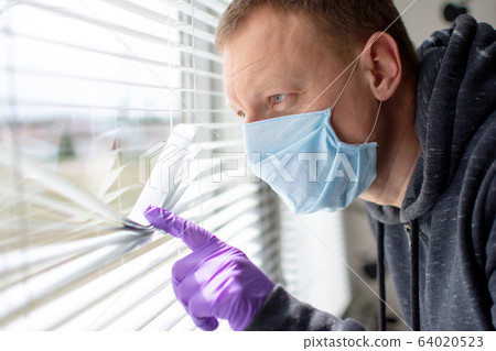 Coronavirus. Sick man of corona virus looking through the window and wearing mask protection . 64020523