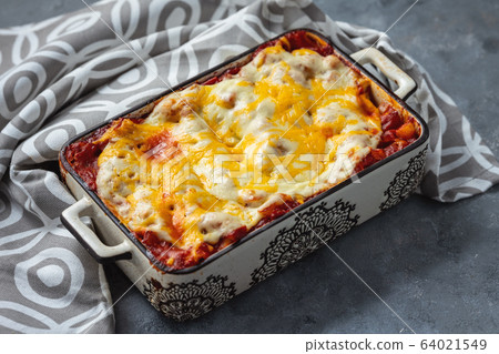 Spinach and ricotta stuffed cannelloni baked in tomato sauce. Spinach and ricotta stuffed cannelloni baked in tomato sauce. 64021549