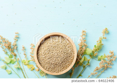 Organic brown quinoa seed in a wooden bowl and quinoa plant on pastel color background, healthy food, top view Organic brown quinoa seed in a wooden bowl and quinoa plant on pastel color background, healthy food, top view 64022406