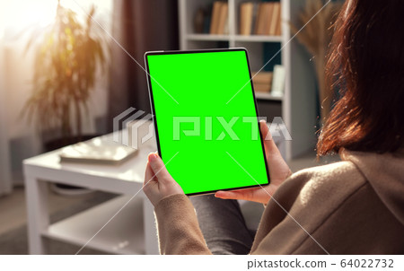 Woman looking at vertical tablet Woman looking at vertical tablet 64022732