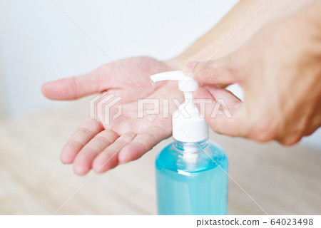 Women washing hands with alcohol gel or 64023498