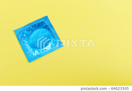 Condom isolated on yellow background - Colorful 64023505