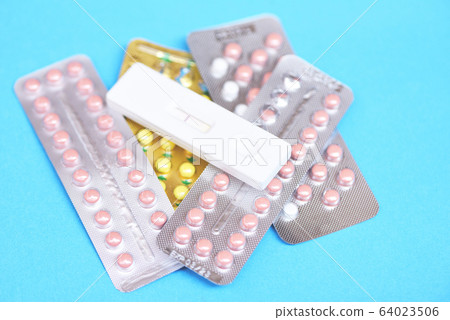 Contraception pills and Pregnancy test on blue Contraception pills and Pregnancy test on blue 64023506